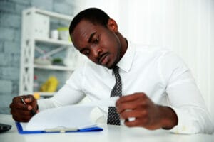 African man reading document in office